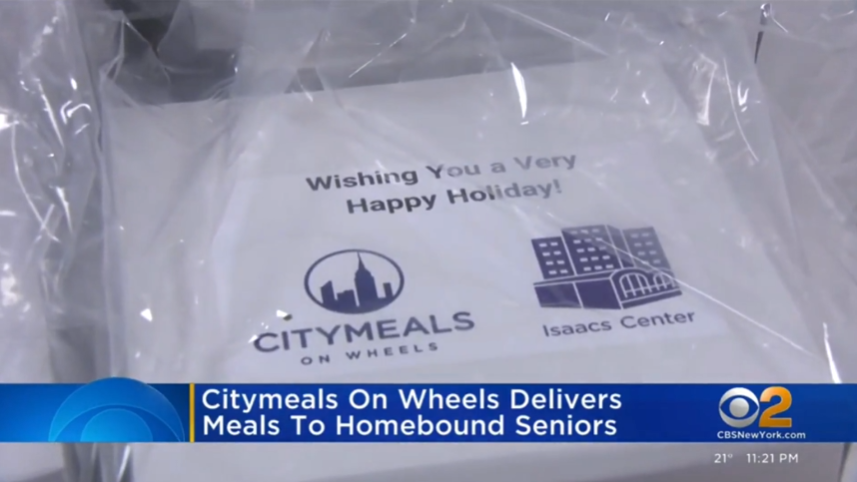 Screenshot of a white carton with a sticker reading Wishing You a Very Happy Holiday!  over the Isaacs Center and Citymeals logos