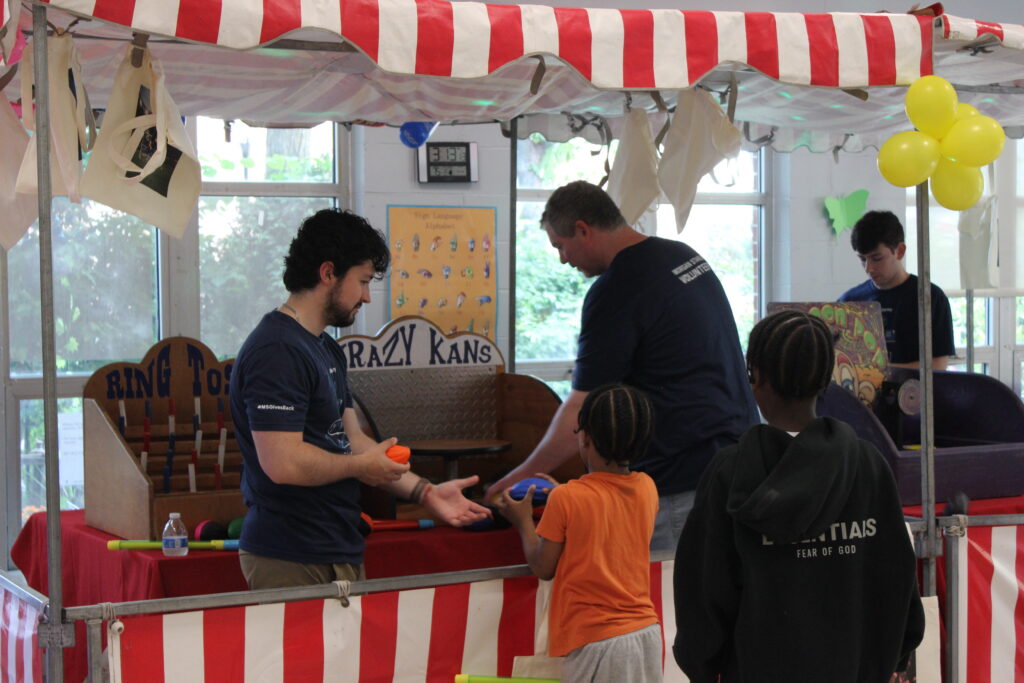 Children getting prizes from volunteers at a booth